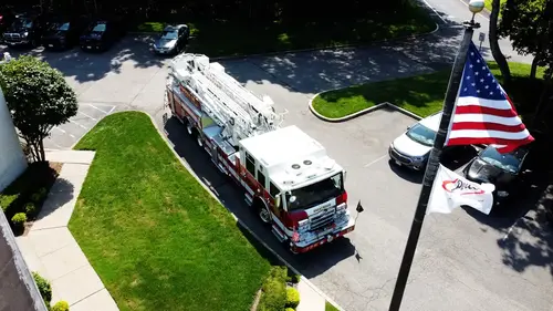 Pierce tower ladder elevated front-right view showing grille, bumper, and aerial bed
