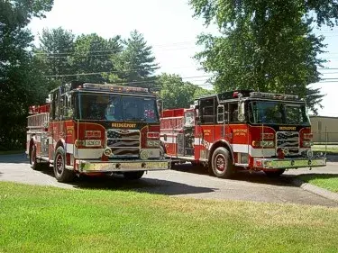 Front-left lineup view of two pumpers parked side-by-side with full front sections visible.