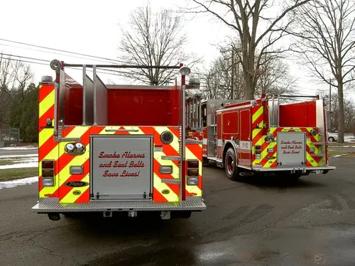 Rear view of two apparatus showing chevrons and rear body panels