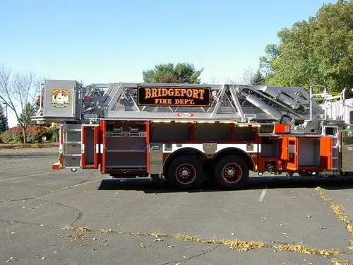 Driver-side profile showing ladder truck body and rear tandem wheels