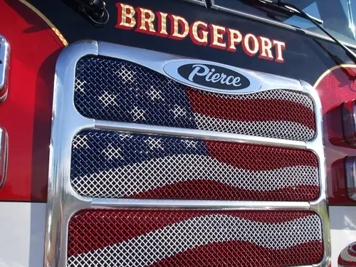 Grille close-up showing mesh pattern, emblem badge, and painted flag design
