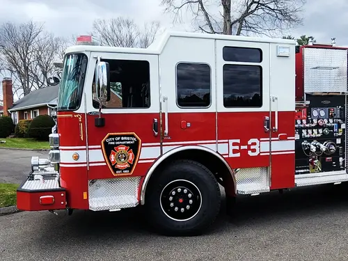 Cab-side close-up showing city crest, side windows, and front wheel area