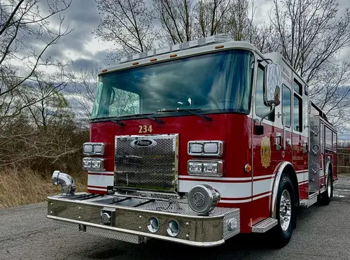 Pumper front view showing grille, headlights, and bumper-mounted siren