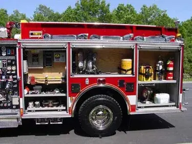 Driver-side profile with open compartments showing pump panel and tools