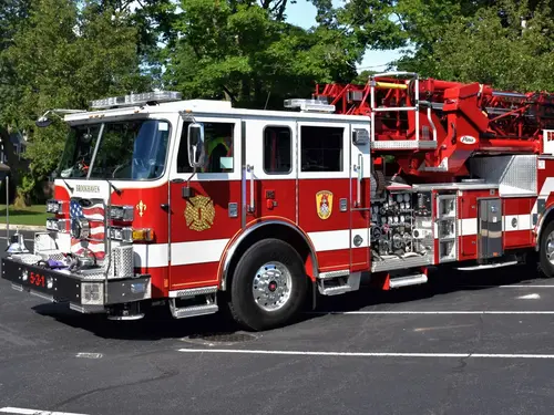 Tower ladder truck front-left exterior view showing ladder base and cab