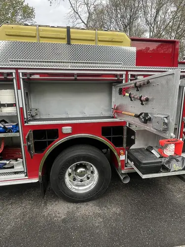 Open side compartments and wheel area showing mounted tools and rear tire