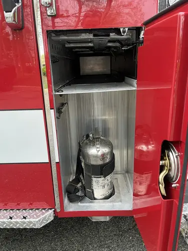 Narrow side compartment with mounted cylinder and under-cab storage
