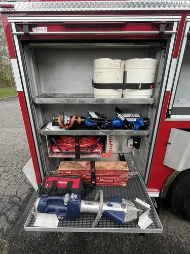 Open upper side compartment above rear wheel showing mounted pike pole and hand tools