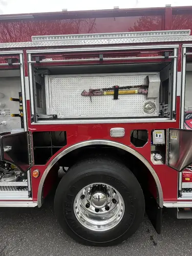 Open side compartment with hose rolls, cribbing blocks, and hydraulic rescue tool on pull-out tray