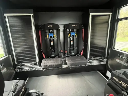 Rear crew compartment interior view with fold-down seats and SCBA seat mounts