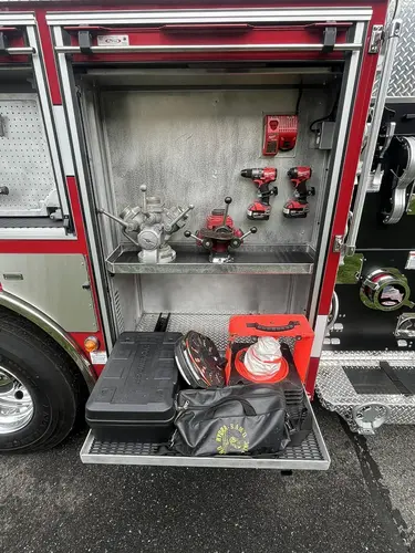Open upper side compartment above rear wheel showing mounted hand tools and rear tire