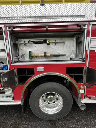 Open upper compartment above rear wheel showing mounted hand tools and wheel area
