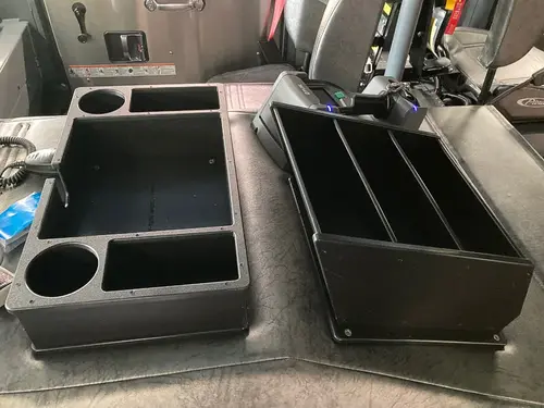 Cab interior center-console close-up showing cup holder and work surface