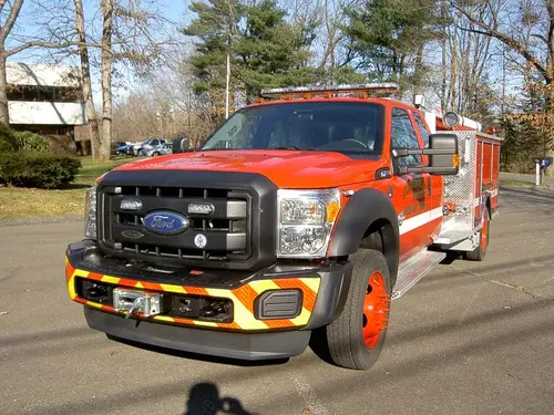 Front-left exterior view of rescue pumper pickup showing grille, winch bumper, and side body