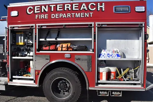 Officer-side body close-up with open compartment showing tools and storage bins
