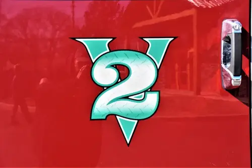 Body emblem close-up showing a green number decal on red panel