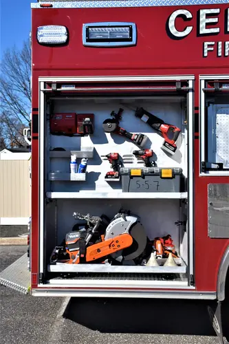 Open side compartment showing arranged hand tools, nozzles, and equipment shelves