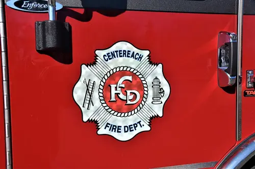 Cab door close-up showing a chrome department crest badge on red paint