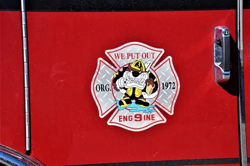 Cab door close-up showing a Maltese-cross style department crest badge
