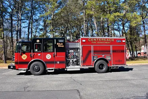 Driver-side profile view showing pumper body, side compartments, and rear section