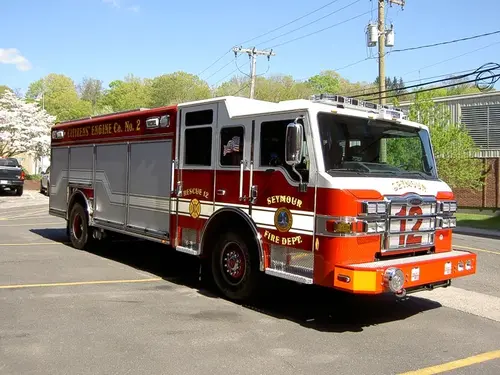 Pumper front-left exterior view parked by station with side body visible