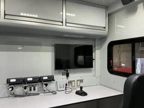 Command workspace interior with monitor, radios, and countertop desk