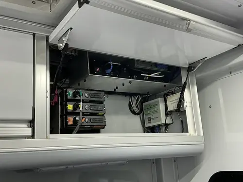 Overhead cabinet compartment open above command workstation