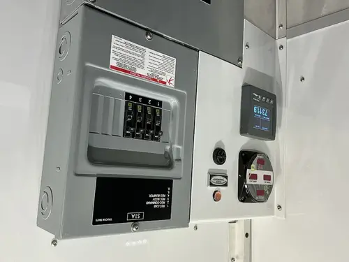 Electrical control panel close-up with breaker switches and shore power gauge