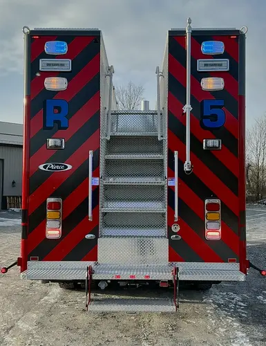 Rear body close-up showing chevrons, warning lights, and center stair