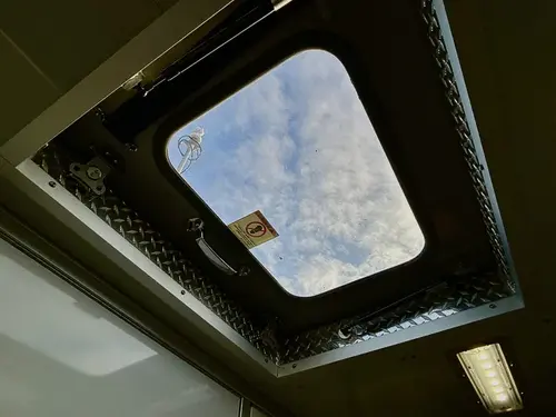 Interior roof hatch close-up showing open skylight and latch hardware