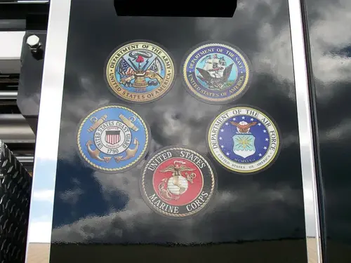 Cab window close-up showing multiple department emblems and decals