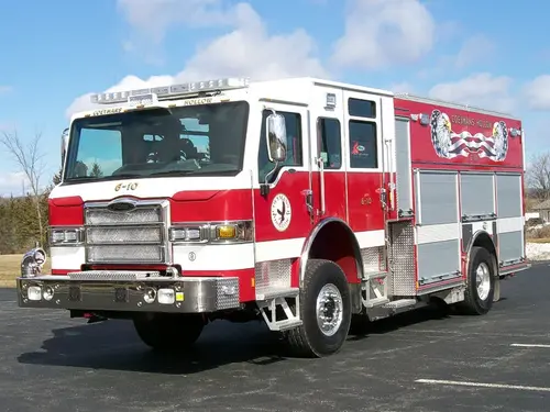 Front-right exterior view of a rescue pumper with enclosed cab, side compartments, and wheel/tire area.