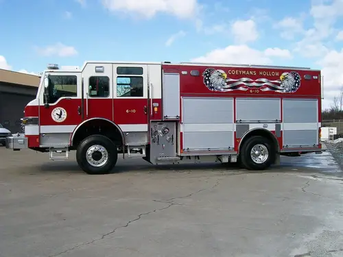 Driver-side full profile showing the pump panel section, side compartments, and full wheelbase.