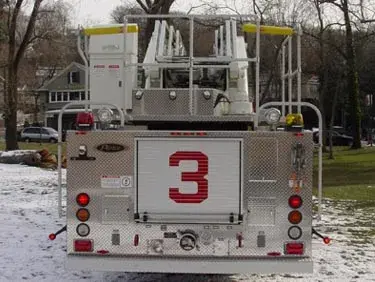 Rear view showing aerial ladder base, rear body panel, and warning lights