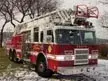 Front-left exterior view showing cab and aerial ladder assembly
