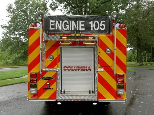 Rear view showing chevron striping, rear roll-up door, and warning lights
