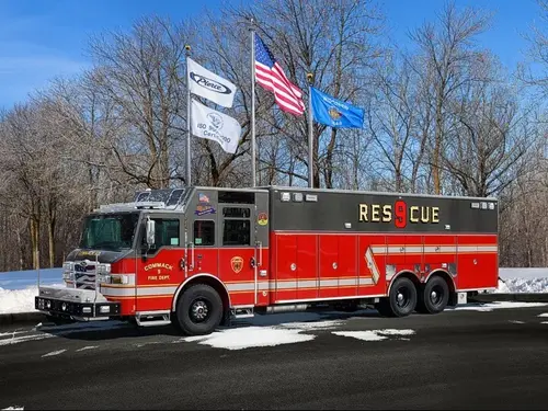 Heavy rescue truck front-left exterior view parked near flags