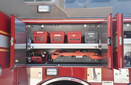 Open compartment showing stacked red storage cases and tool bags