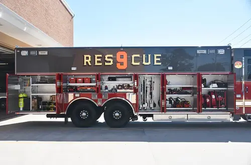 Heavy rescue truck side profile view showing open compartments and large unit lettering