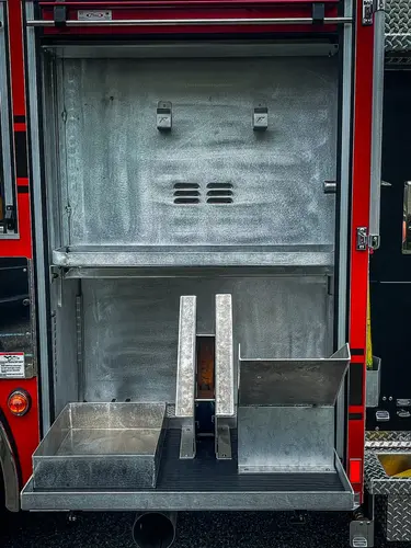 Open rear body compartment showing empty slide-out tray and mounting rails