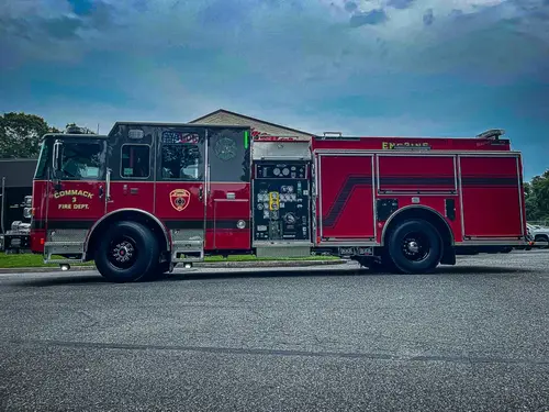 Driver-side full profile view showing pumper body and side compartments