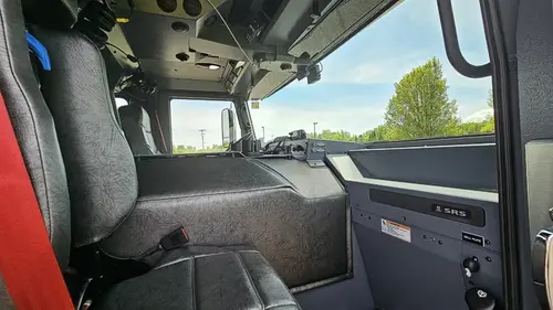 Cab interior side view showing front seat, dashboard, and windshield