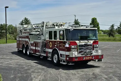 Front-left exterior view showing cab corner and aerial ladder over body
