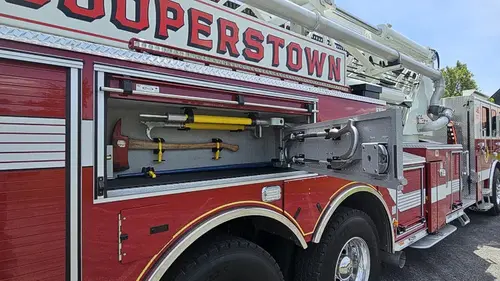 Driver-side mid-body view showing ladder beam and side stripe lettering