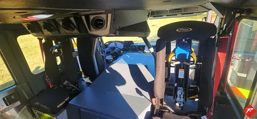 Rear crew cab interior view showing seats, center aisle, and door opening