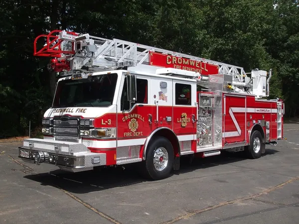 Tower ladder front-left exterior view showing enclosed cab and ladder bed