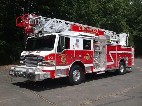 Tower ladder front-left exterior view showing enclosed cab and ladder bed