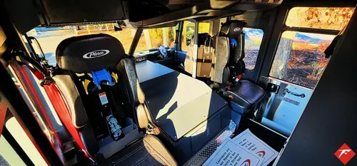 Cab interior side view showing front seats, center console, and dashboard