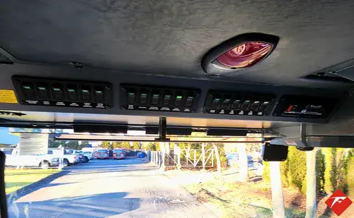 Overhead console close-up showing rocker switches and warning labels