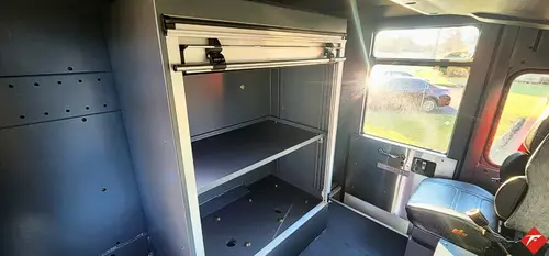 Cab interior view showing rear crew seating and storage cubby